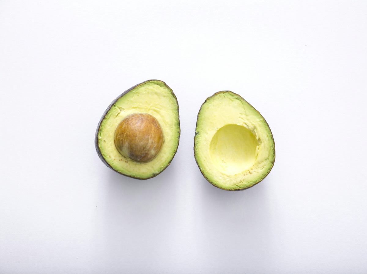 Fresh avocado halves on a light surface